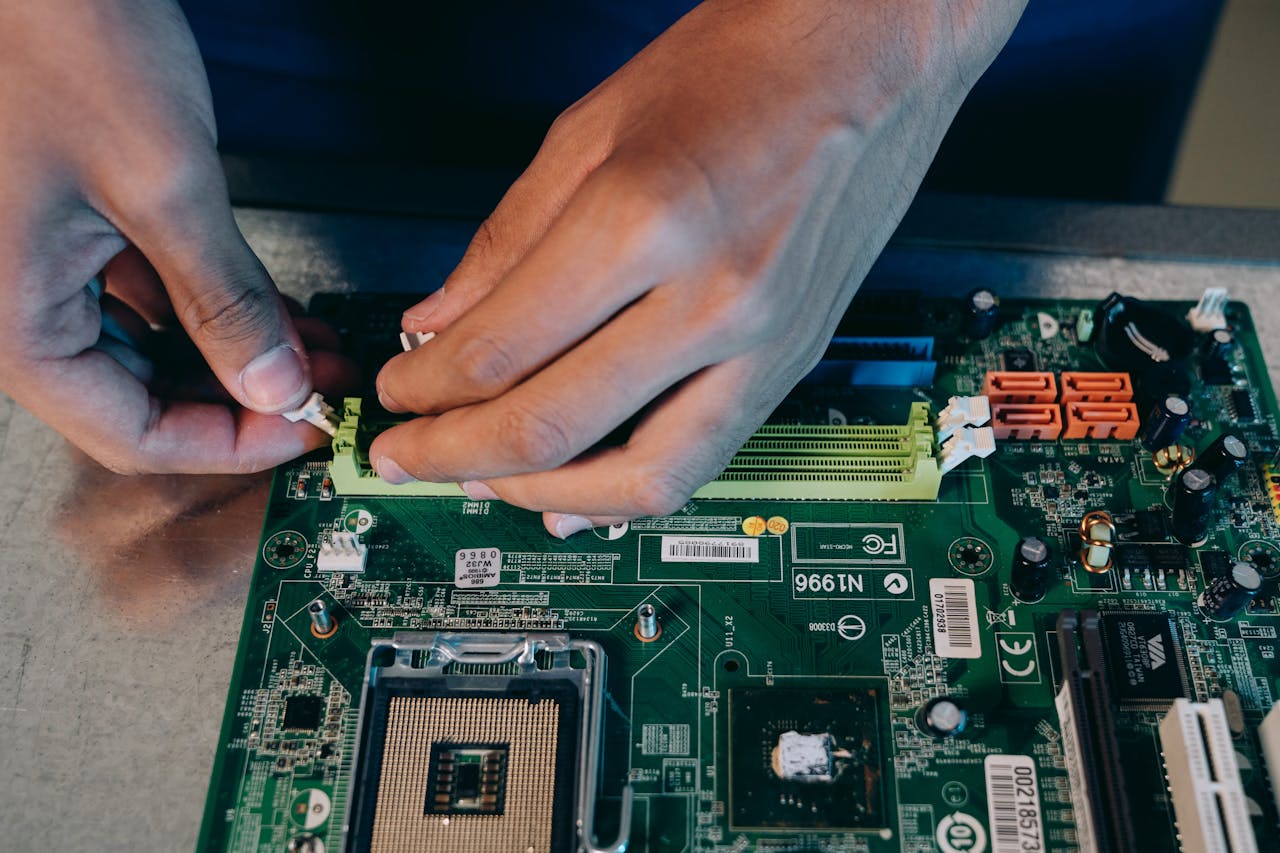 services-03 Hands carefully assembling a computer motherboard, showcasing technical craftsmanship in electronics.